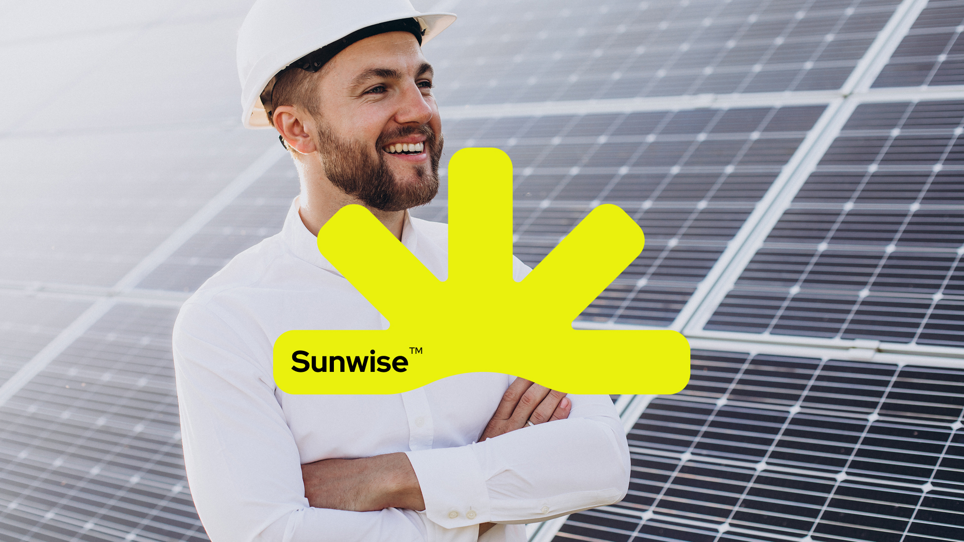 Hombre con casco y el isotipo Sunwise sobre paneles solares